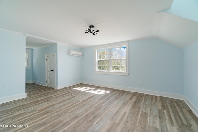 bonus room with vaulted ceiling, hardwood / wood-style flooring, and a wall mounted AC