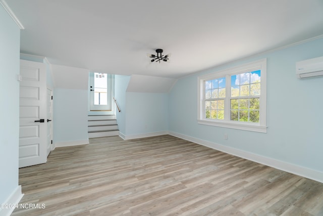 interior space featuring crown molding, light hardwood / wood-style floors, and a wall mounted air conditioner