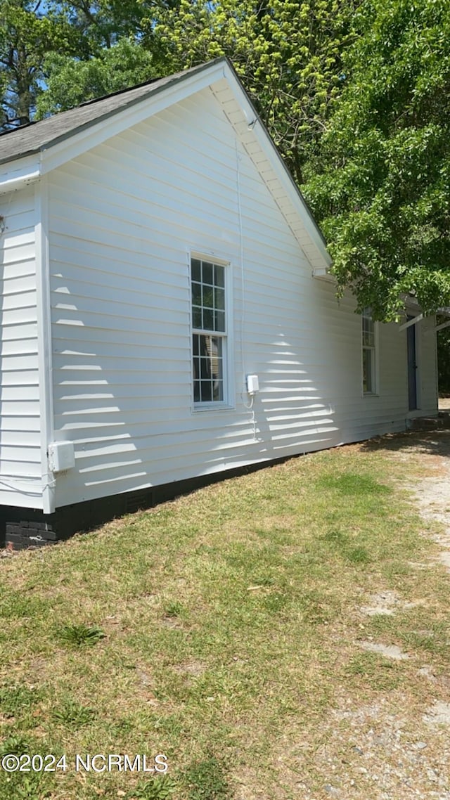 view of side of home with a yard