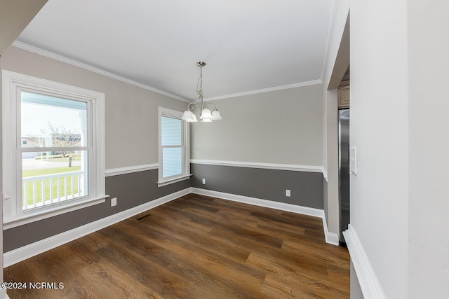 empty room with a chandelier, ornamental molding, and dark wood-type flooring