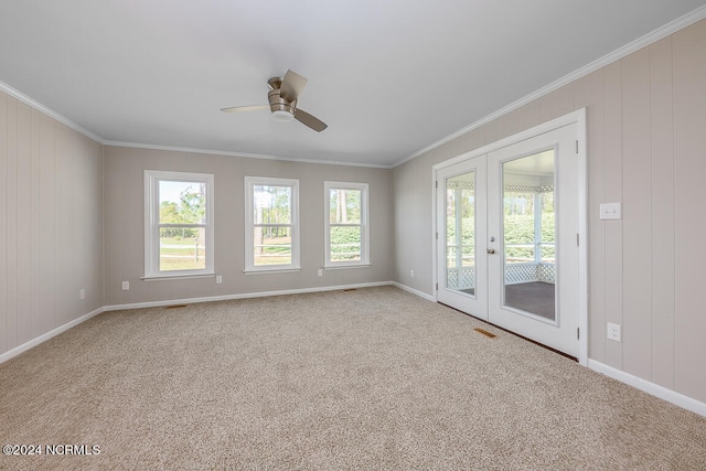 carpeted empty room featuring french doors, ceiling fan, and ornamental molding