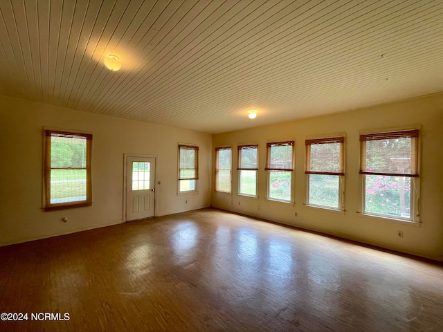 spare room featuring light hardwood / wood-style flooring, a wealth of natural light, and wood ceiling