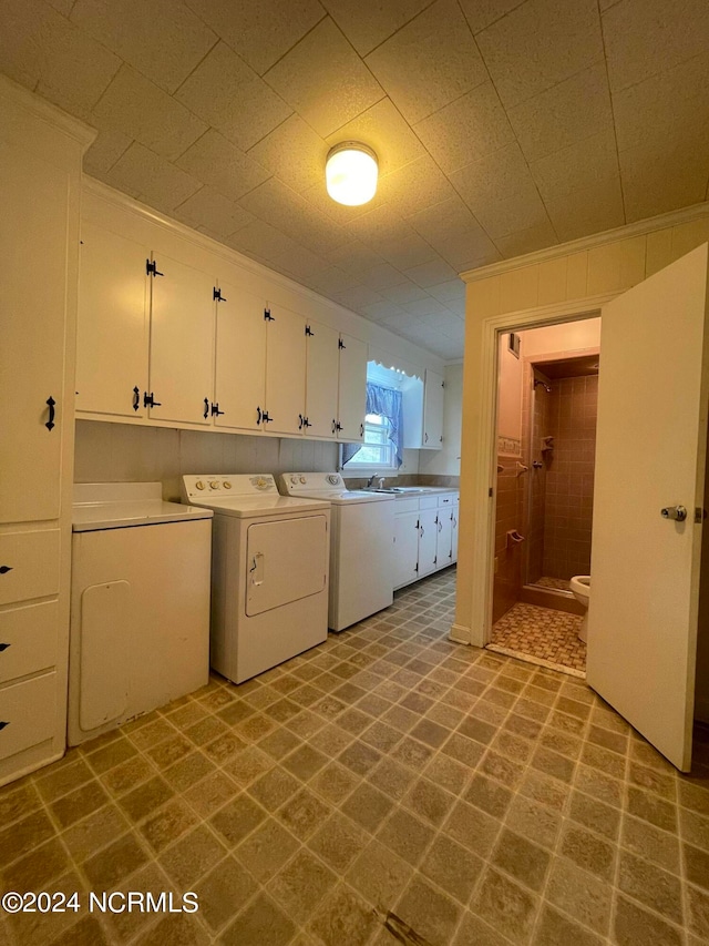 laundry area with tile flooring, sink, cabinets, and washer and clothes dryer