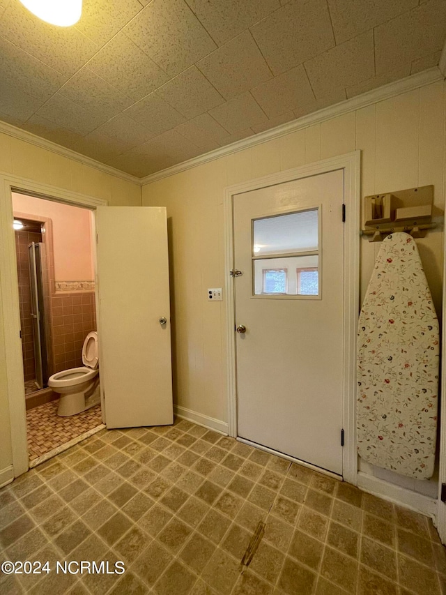 interior space with dark tile flooring and crown molding