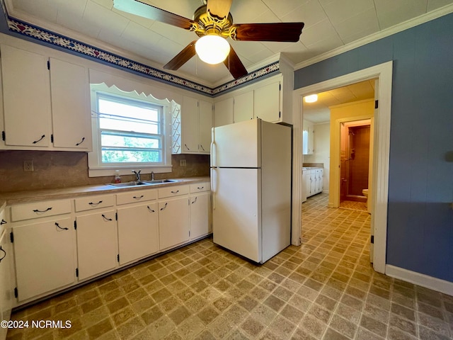 kitchen featuring white refrigerator, tasteful backsplash, and white cabinetry