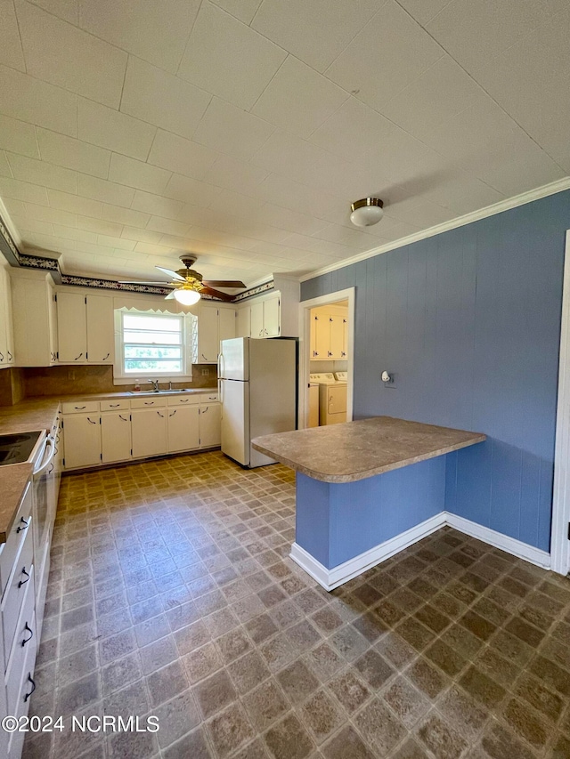 kitchen featuring washing machine and dryer, white appliances, ceiling fan, crown molding, and dark tile floors