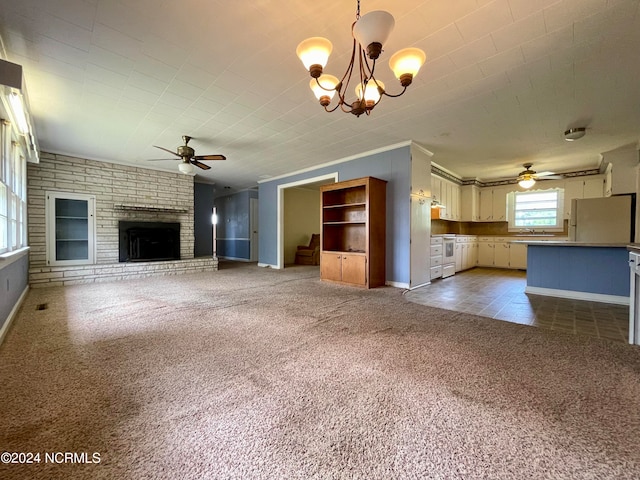 unfurnished living room with ceiling fan with notable chandelier, sink, light carpet, and a brick fireplace