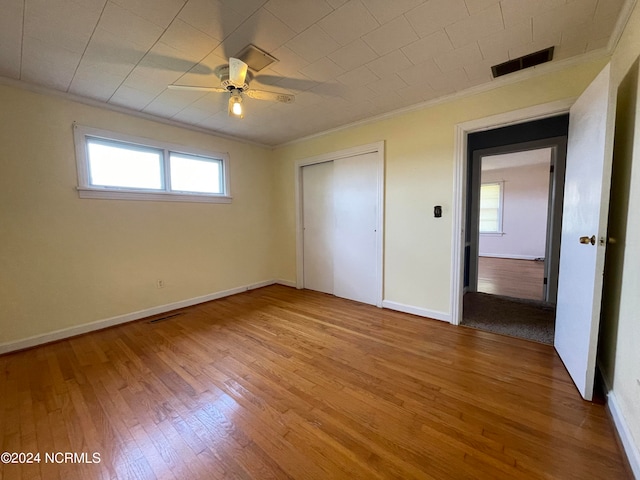 unfurnished bedroom with light hardwood / wood-style floors, ceiling fan, and multiple windows