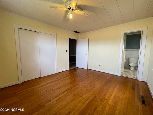 unfurnished bedroom with hardwood / wood-style floors, connected bathroom, ceiling fan, and ornamental molding