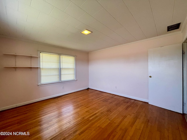 empty room featuring dark hardwood / wood-style flooring and crown molding