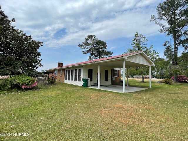 rear view of property featuring a patio and a yard