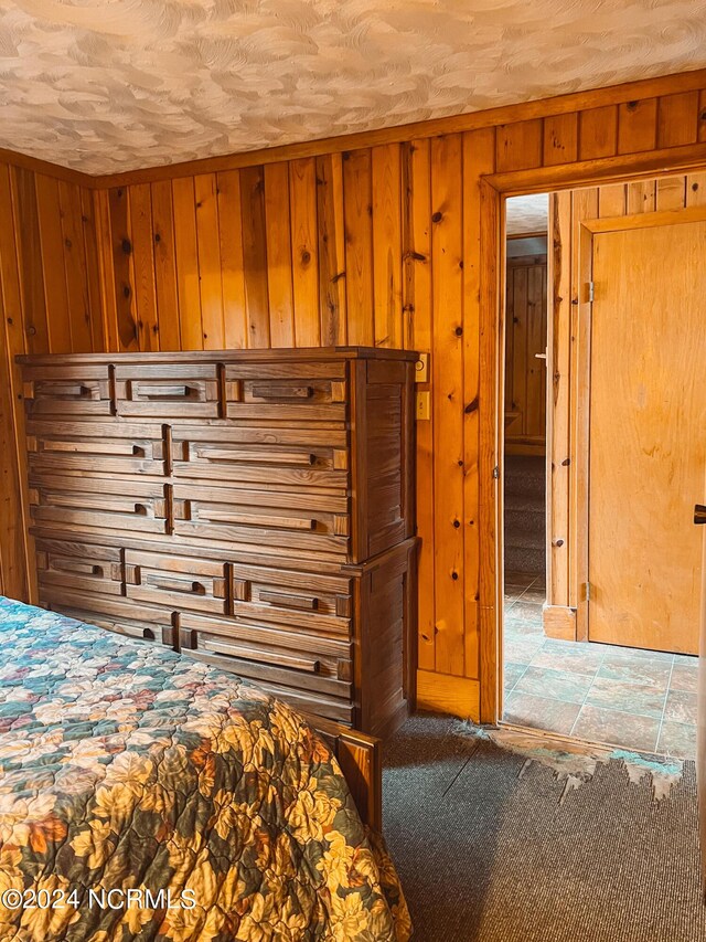 bonus room with wood walls, vaulted ceiling, and carpet flooring