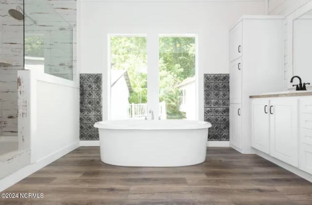 bathroom featuring hardwood / wood-style floors, vanity, and a bath to relax in