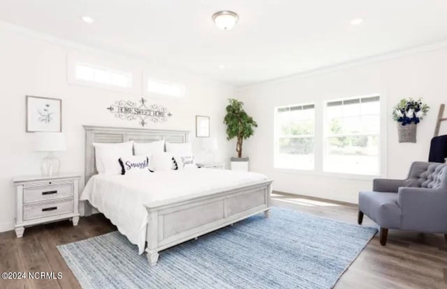 bedroom with ornamental molding and dark hardwood / wood-style flooring