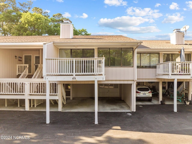 back of house featuring a carport