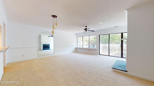 carpeted empty room with ceiling fan, a textured ceiling, and a fireplace