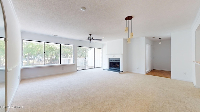 unfurnished living room with a textured ceiling, ceiling fan, and carpet flooring