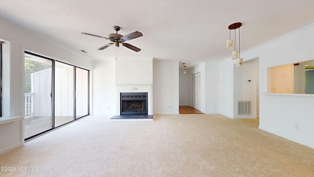 unfurnished living room with crown molding, light carpet, ceiling fan, and a textured ceiling