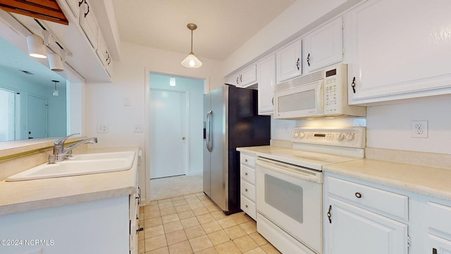 kitchen featuring light tile floors, sink, white appliances, white cabinetry, and decorative light fixtures