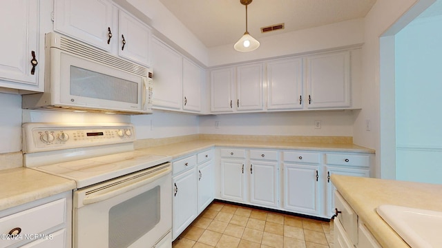 kitchen featuring white appliances, white cabinetry, pendant lighting, and light tile floors