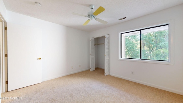 spare room with ceiling fan, carpet floors, and a textured ceiling