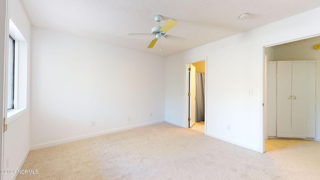 unfurnished room featuring a textured ceiling, ceiling fan, and light carpet