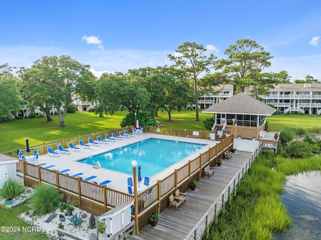 view of swimming pool with a yard and a sunroom