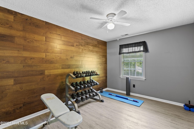 167 Dockside Dr, Jacksonville, NC 28546 - workout room featuring wooden walls, wood finished floors, a textured ceiling, a ceiling fan, and baseboards