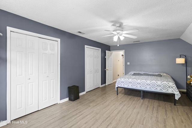 167 Dockside Dr, Jacksonville, NC 28546 - bedroom featuring two closets, wood finished floors, baseboards, a ceiling fan, and a textured ceiling