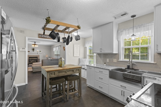 167 Dockside Dr, Jacksonville, NC 28546 - kitchen featuring freestanding refrigerator, a sink, backsplash, a textured ceiling, and pendant lighting