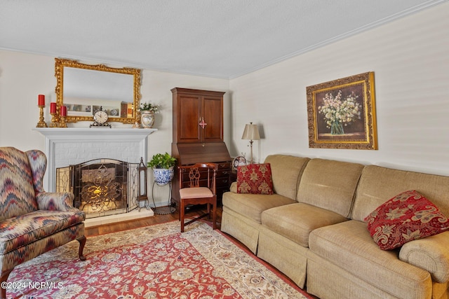 living room with hardwood / wood-style flooring, ornamental molding, and a fireplace