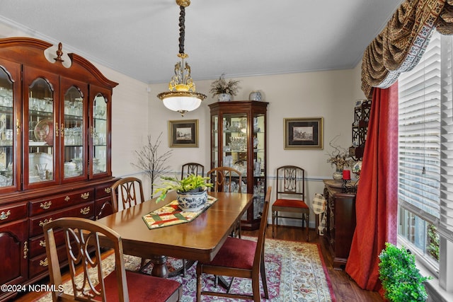 dining space with crown molding and dark hardwood / wood-style flooring