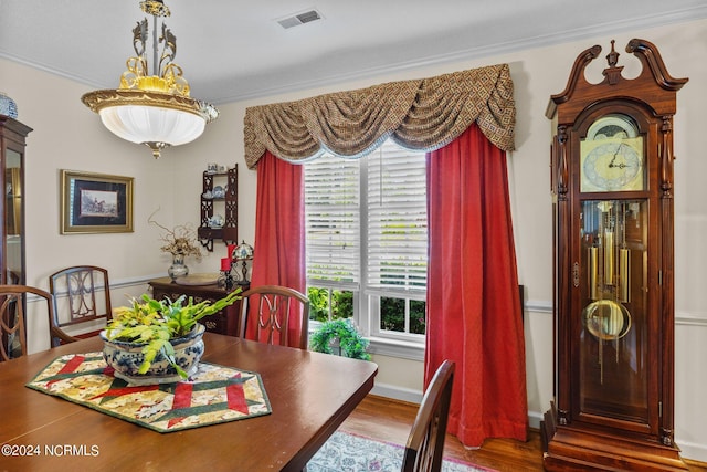 dining room with hardwood / wood-style floors and ornamental molding