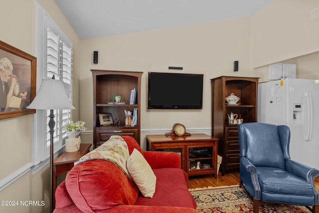 living room featuring wood-type flooring and vaulted ceiling