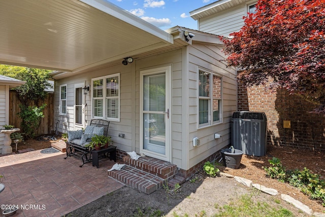 view of side of property with a patio and central AC