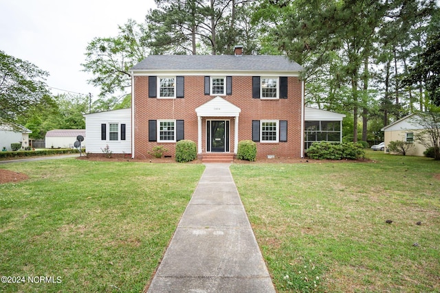 colonial inspired home featuring a front lawn