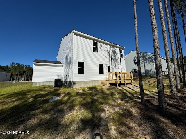 back of property featuring a yard, cooling unit, and a wooden deck