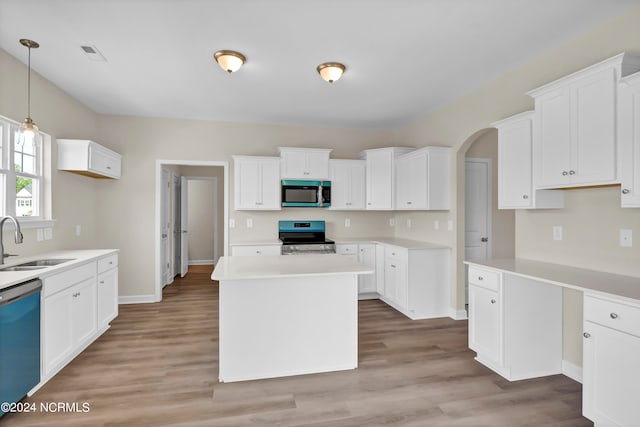 kitchen with sink, appliances with stainless steel finishes, light wood-type flooring, and white cabinetry