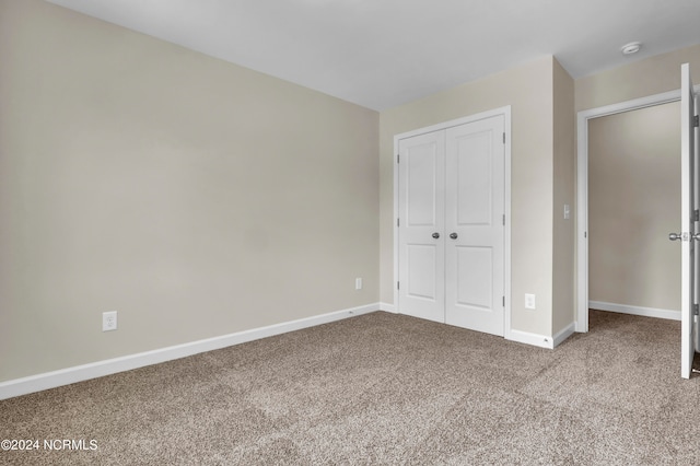 unfurnished bedroom with a closet and carpet floors