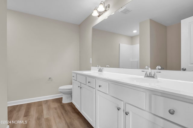 bathroom with vanity, toilet, and wood-type flooring