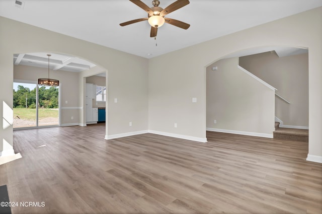 unfurnished living room featuring coffered ceiling, ceiling fan, hardwood / wood-style flooring, and beam ceiling