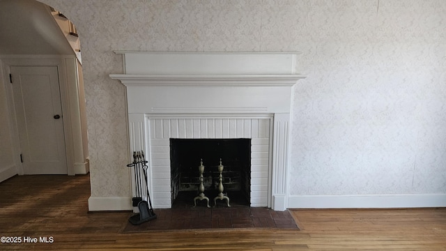 room details featuring a fireplace, baseboards, and wood finished floors