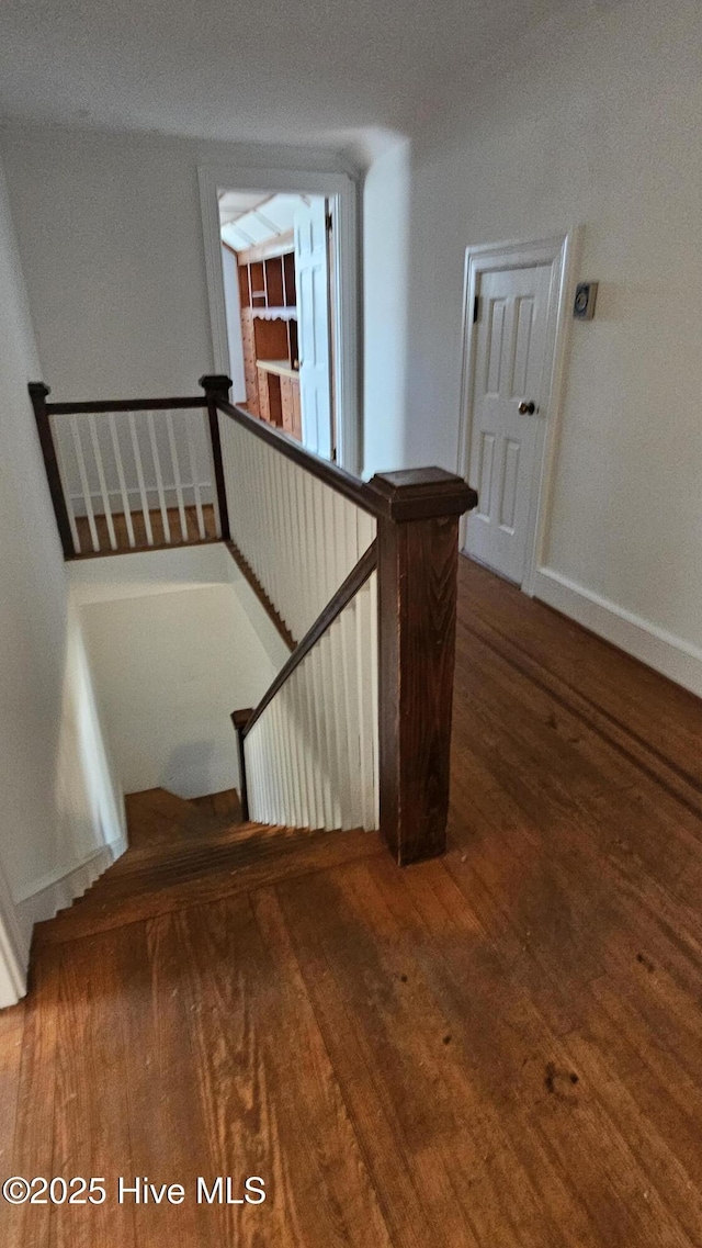 stairway with baseboards and hardwood / wood-style floors