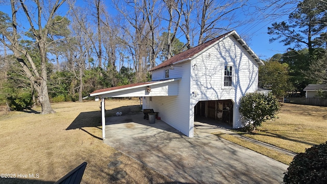 view of side of property with a carport and concrete driveway