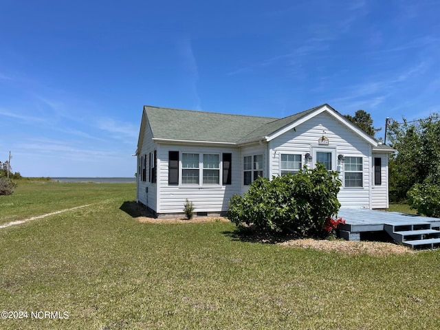 view of side of home with a wooden deck and a lawn