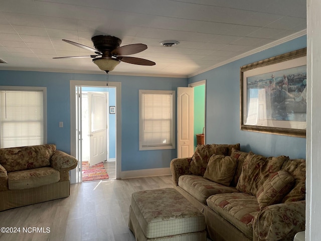 living room featuring wood-type flooring, ceiling fan, and crown molding