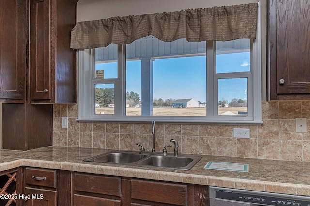 kitchen featuring dishwasher, decorative backsplash, dark brown cabinetry, and sink