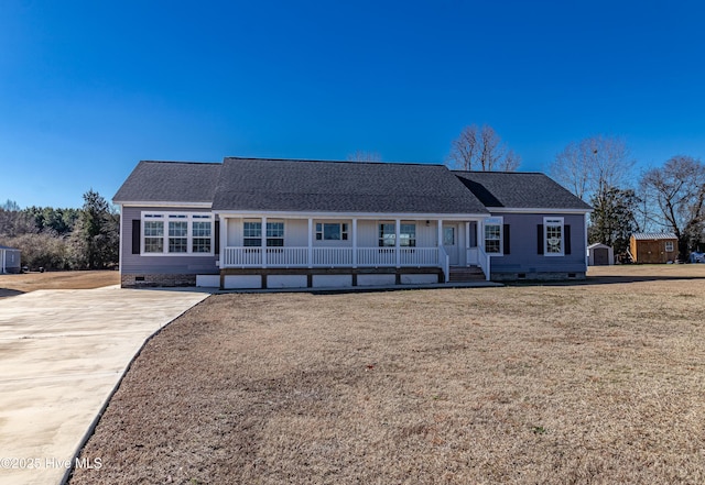 ranch-style house with a front lawn, covered porch, and a storage shed