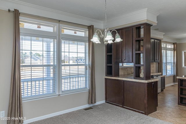 kitchen featuring pendant lighting, dark brown cabinets, crown molding, and a chandelier