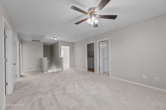 unfurnished bedroom featuring light carpet, connected bathroom, washer / clothes dryer, and ceiling fan